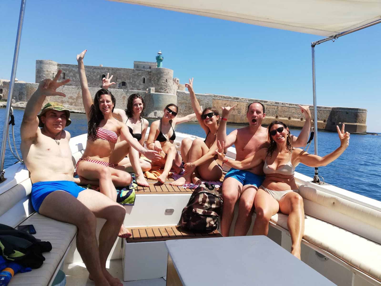 Ospiti felici a bordo davanti al Castello Maniace